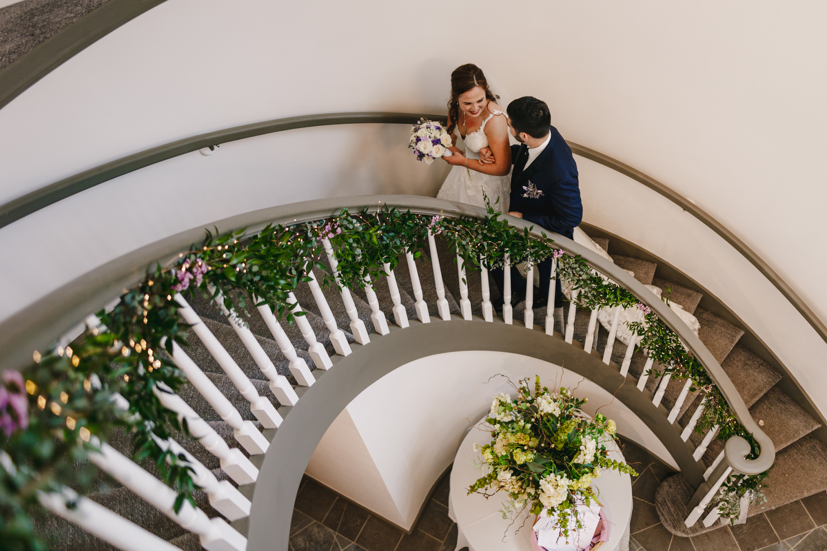 Bride and Groom walk up circular staircase 