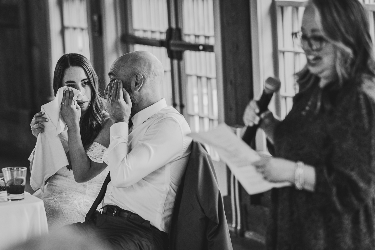 emotional bride and groom listen to toast at quonquont farm wedding reception 