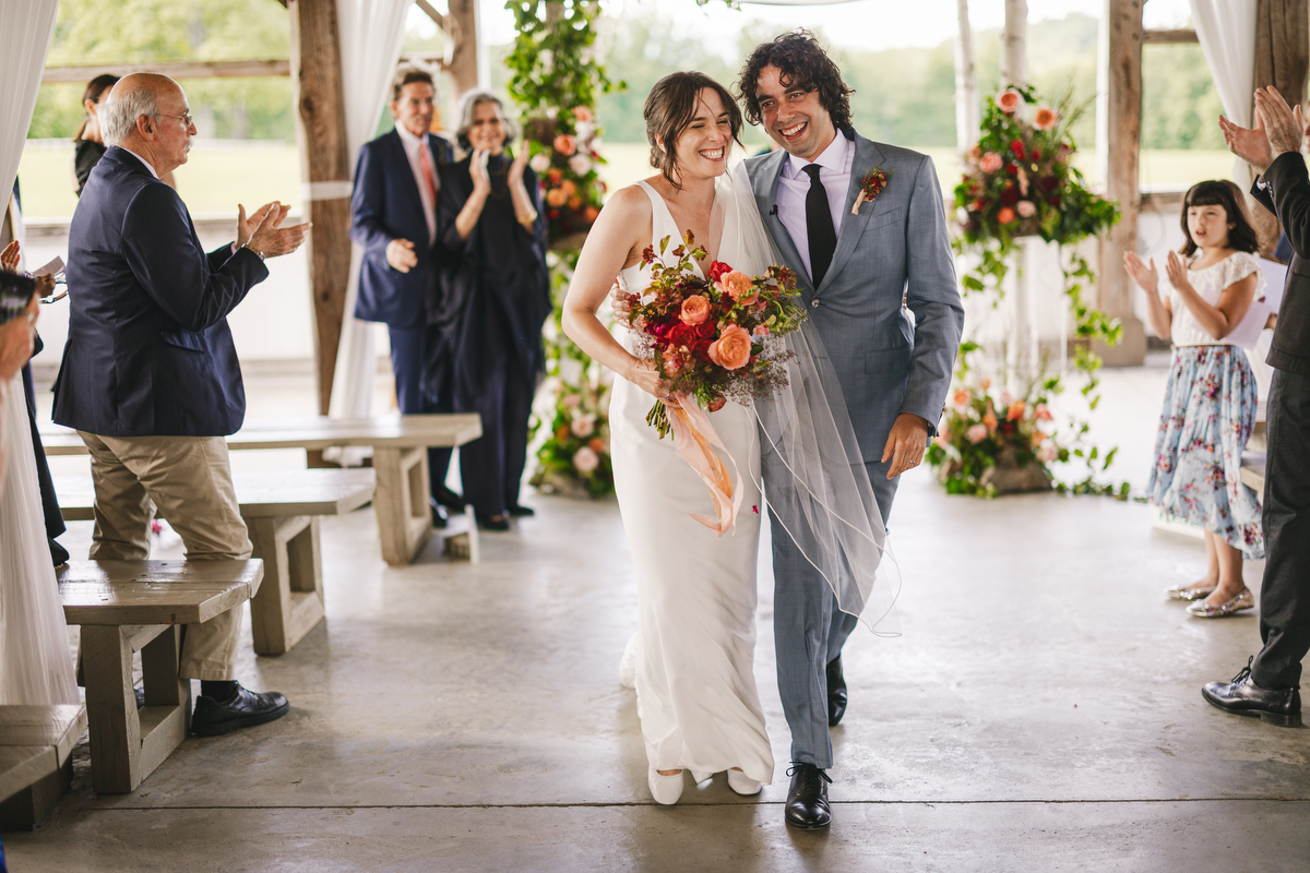 bride and groom smile as they walk down the isle after their wedding ceremony in the pavilion at valley view farm 