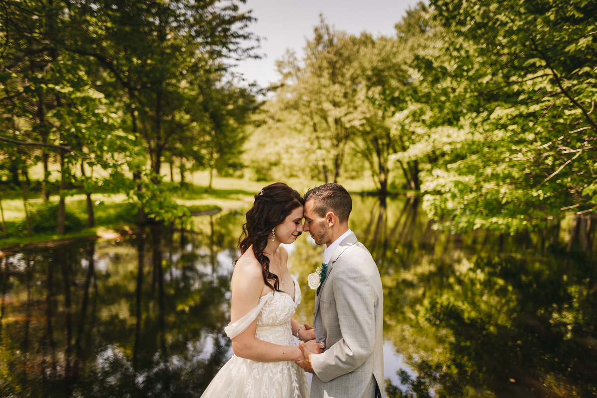 western mass wedding couple standing in front of a pond 