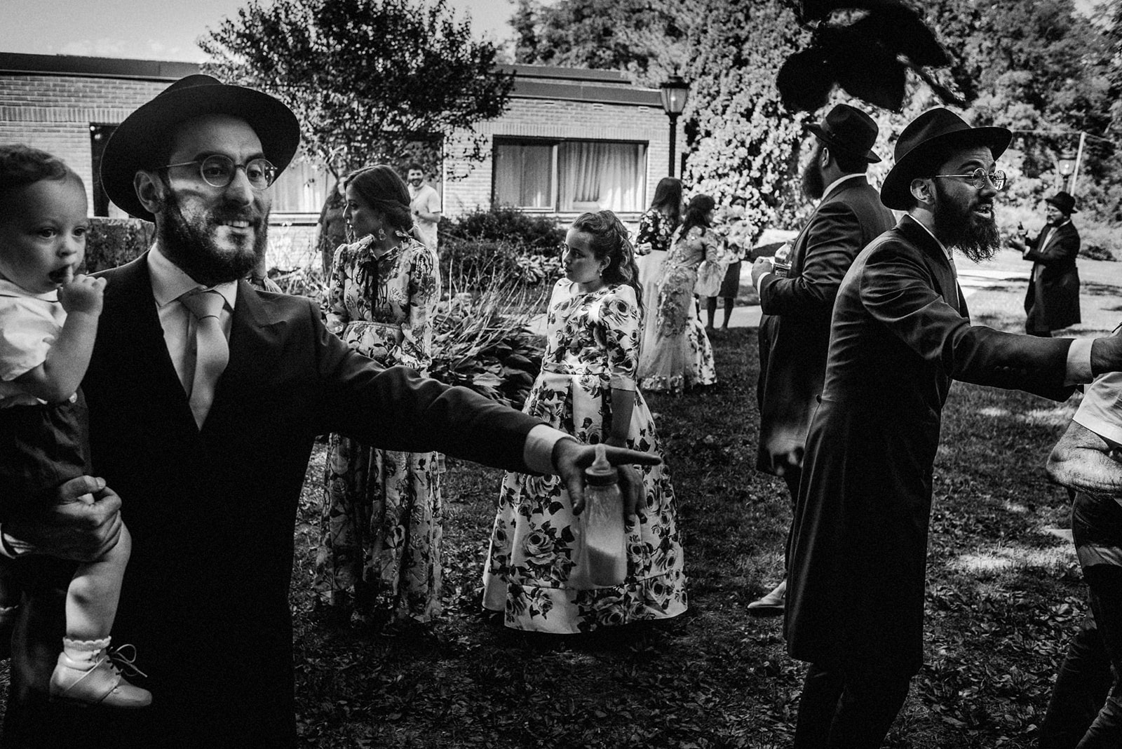 black and white image of crowd of guests at an orthodox jewish wedding and random moments