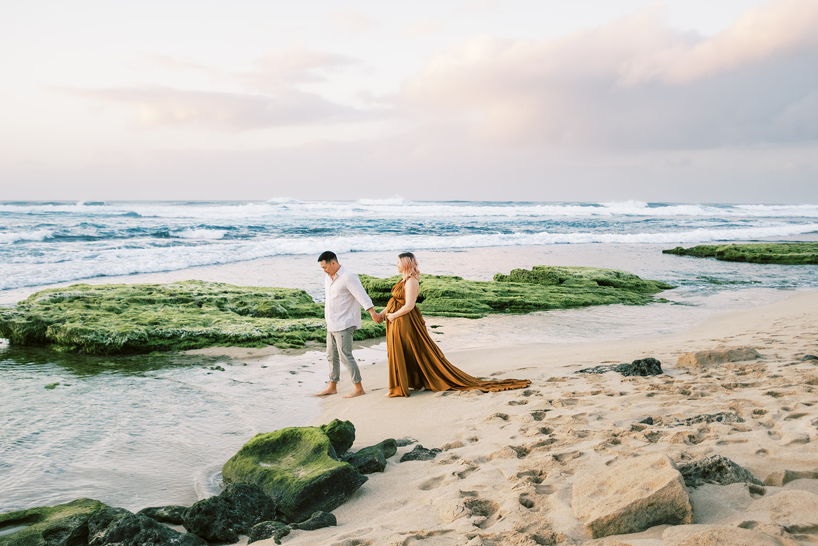 Couple holding hands during their Maternity Session on Oahu during sunset Maternity Session with Megan Moura