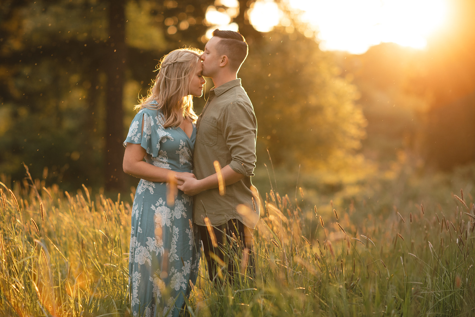 Engagement session in Discovery Park in Seattle with couple standing in a grassy field at sunset.