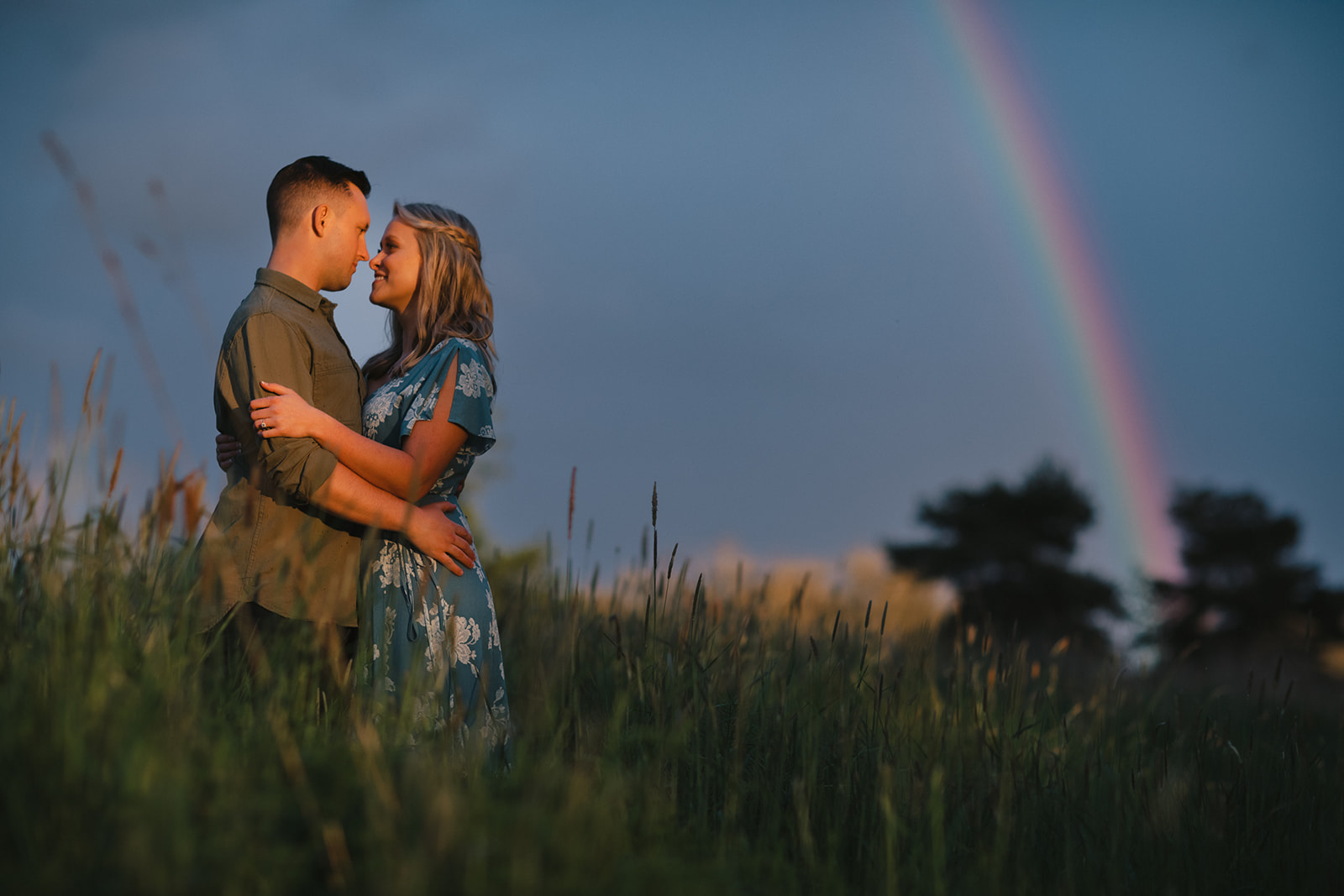 Rainbow in the background of an engagement session in Discovery Park in Seattle.