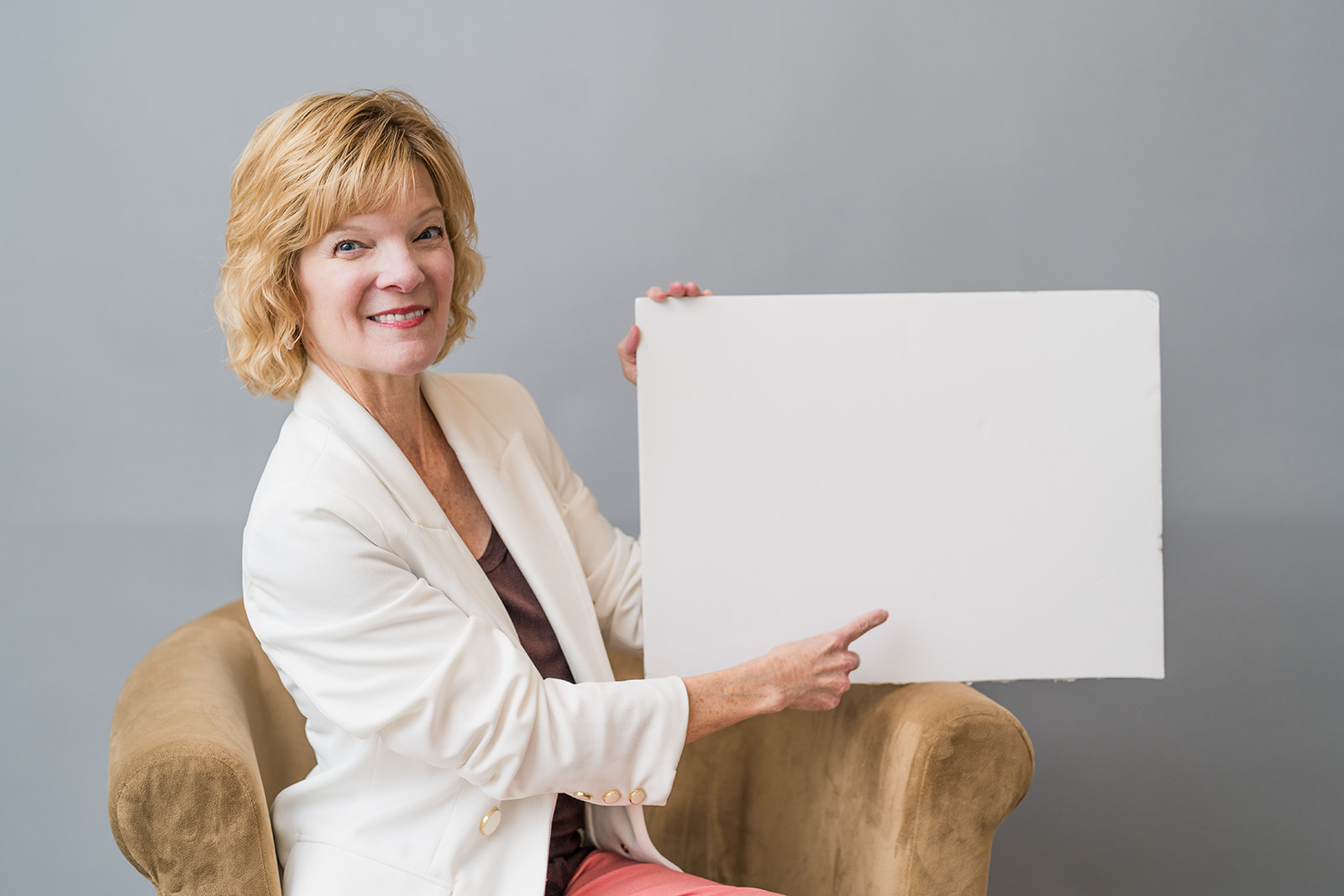 Woman in a white jacket holds a blank page