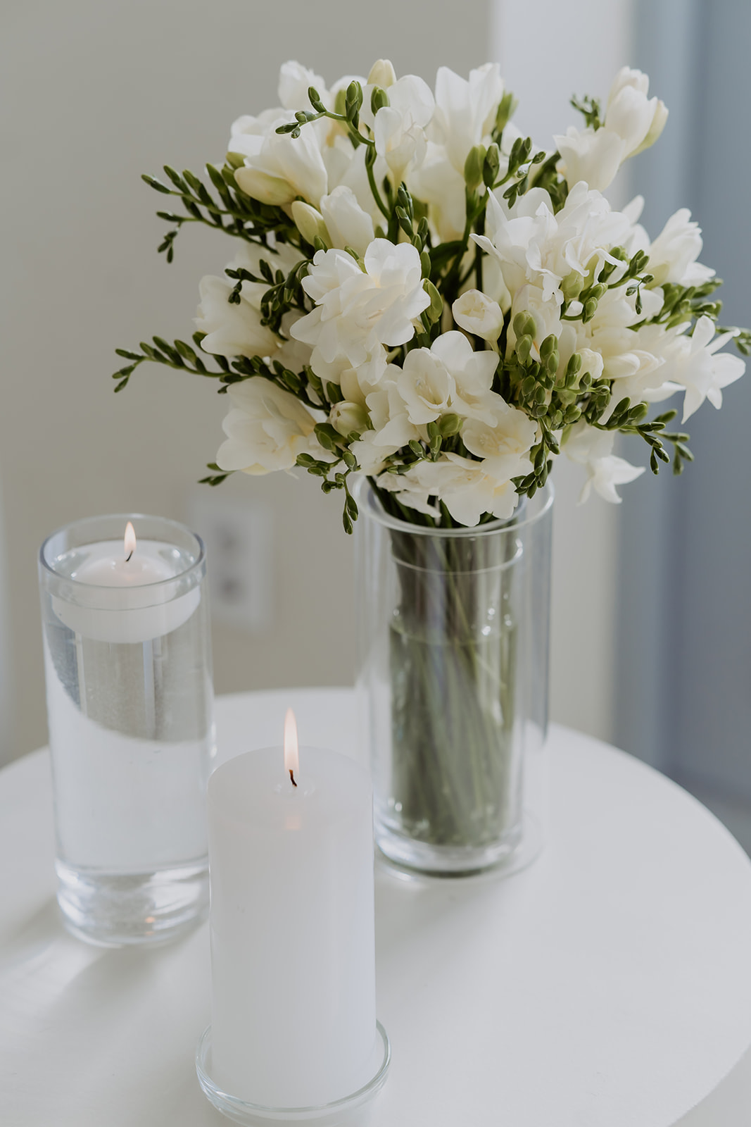 White flowers and a floating candle on a white table