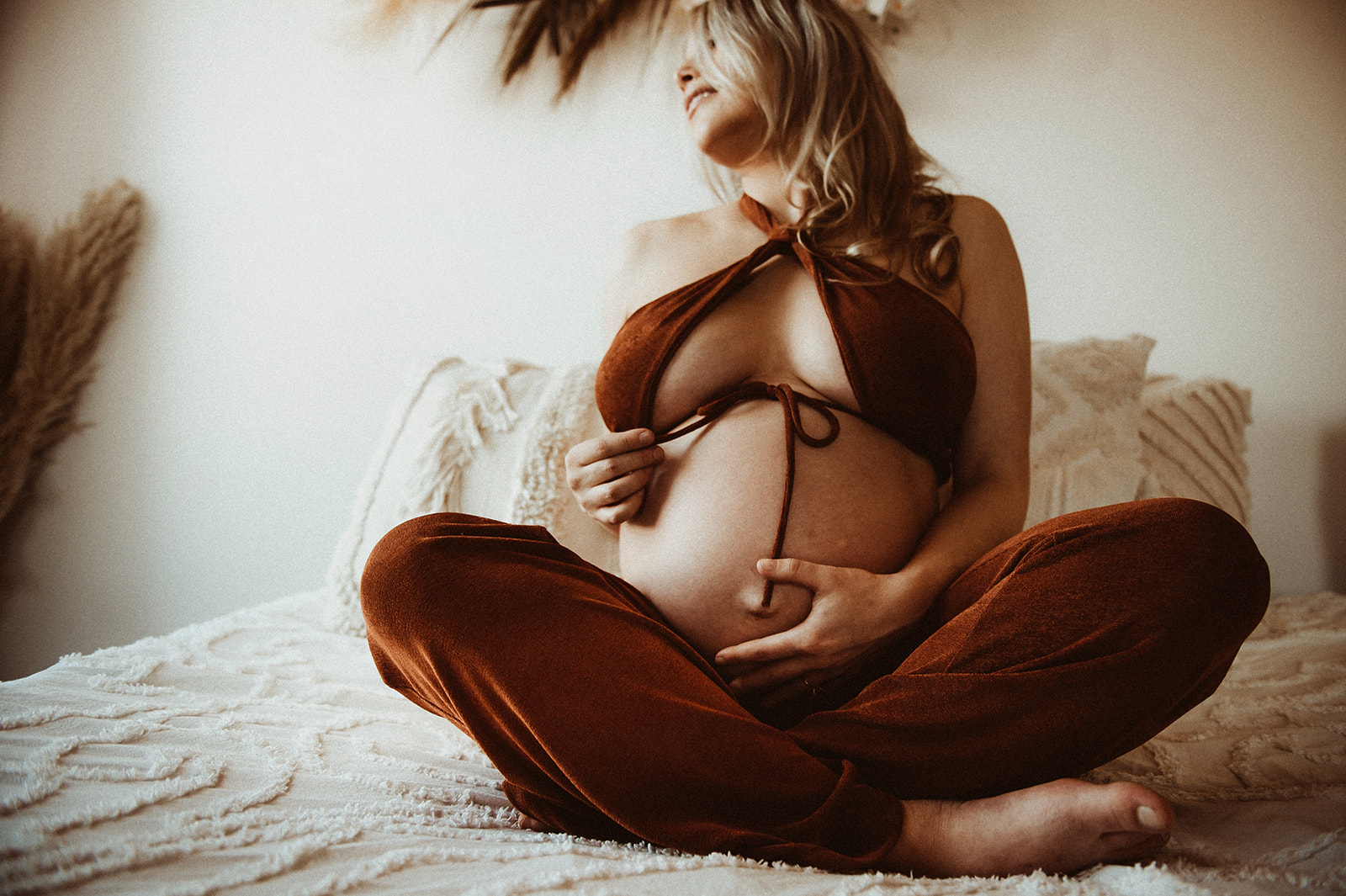 Raw maternity photos of mom wearing a two piece showing off her baby bump