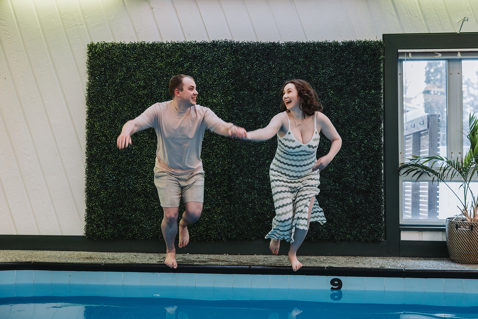 couple jumping into a pool