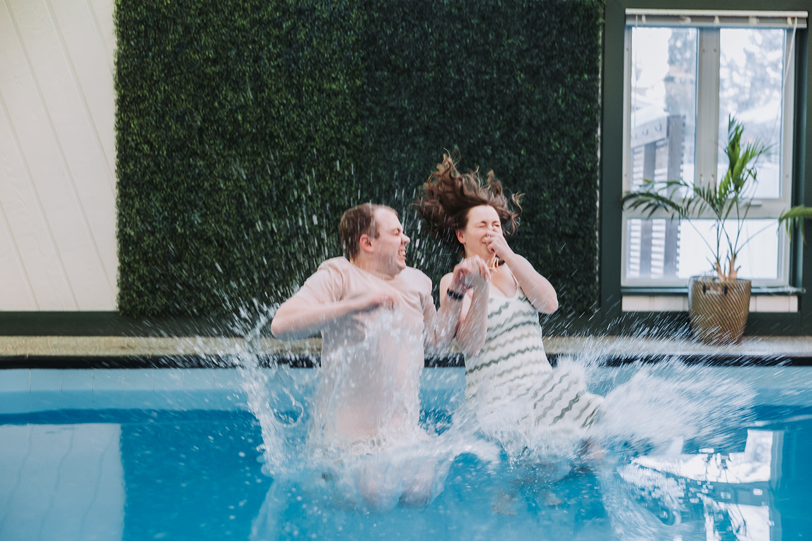 couple splashing into a pool