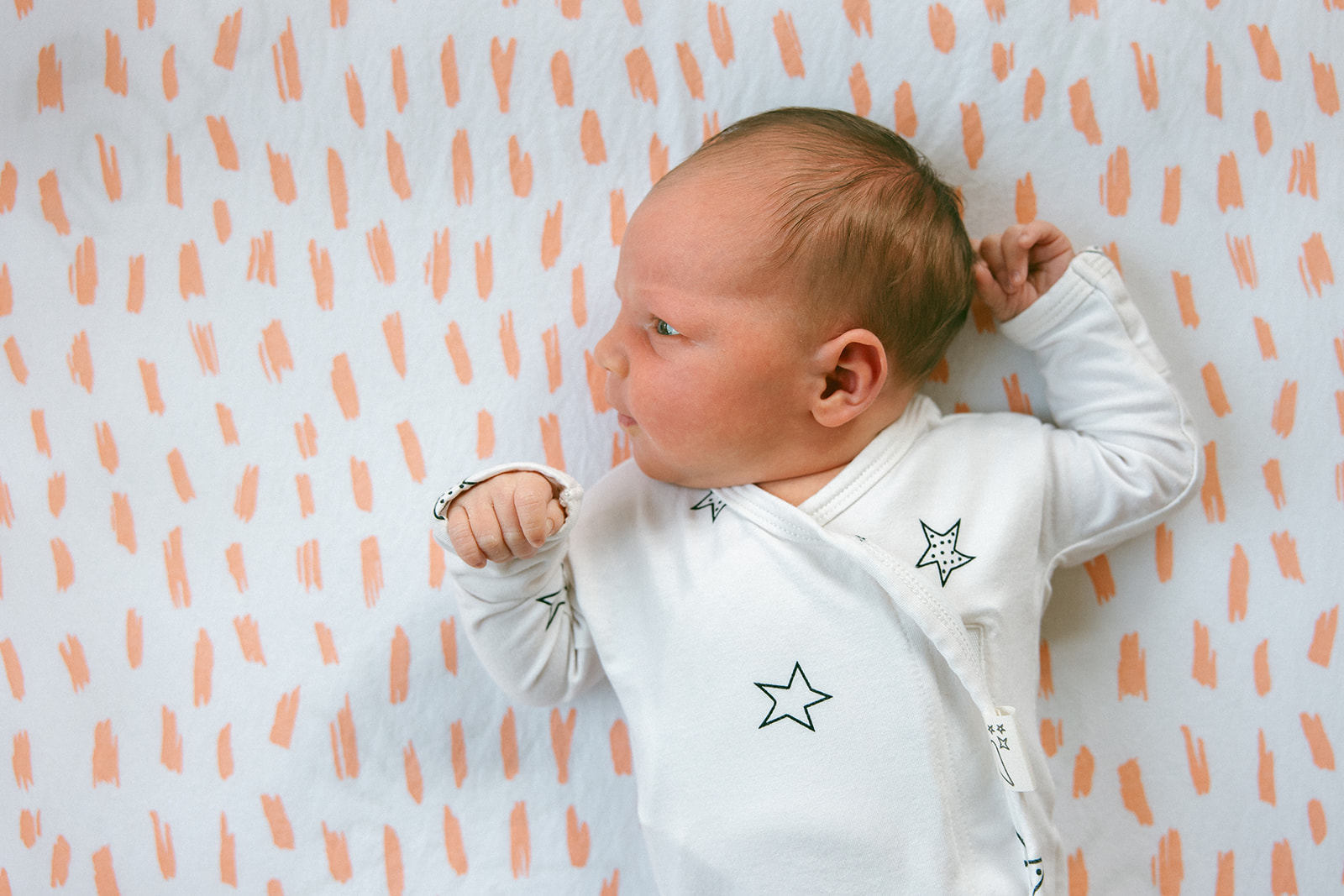 baby in star onesie photographed from above