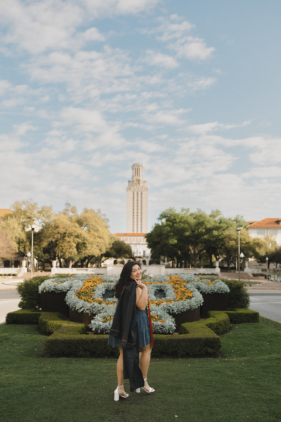 UT Austin senior pictures on the lawn with cap and gown