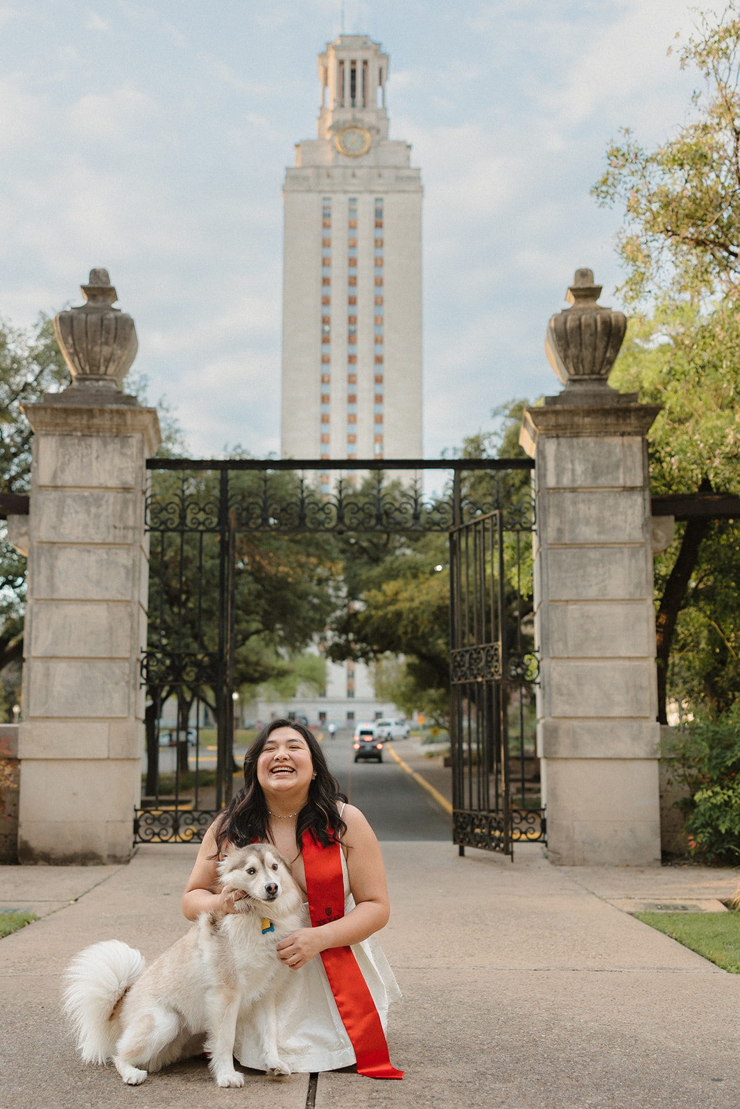 close up UT Austin senior laughing with her dog in front of Gearing Hall Fall 2025