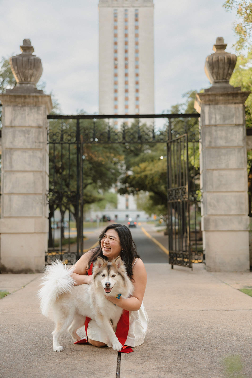 close up UT Austin senior laughing with her dog in front of Gearing Hall Fall 2025
