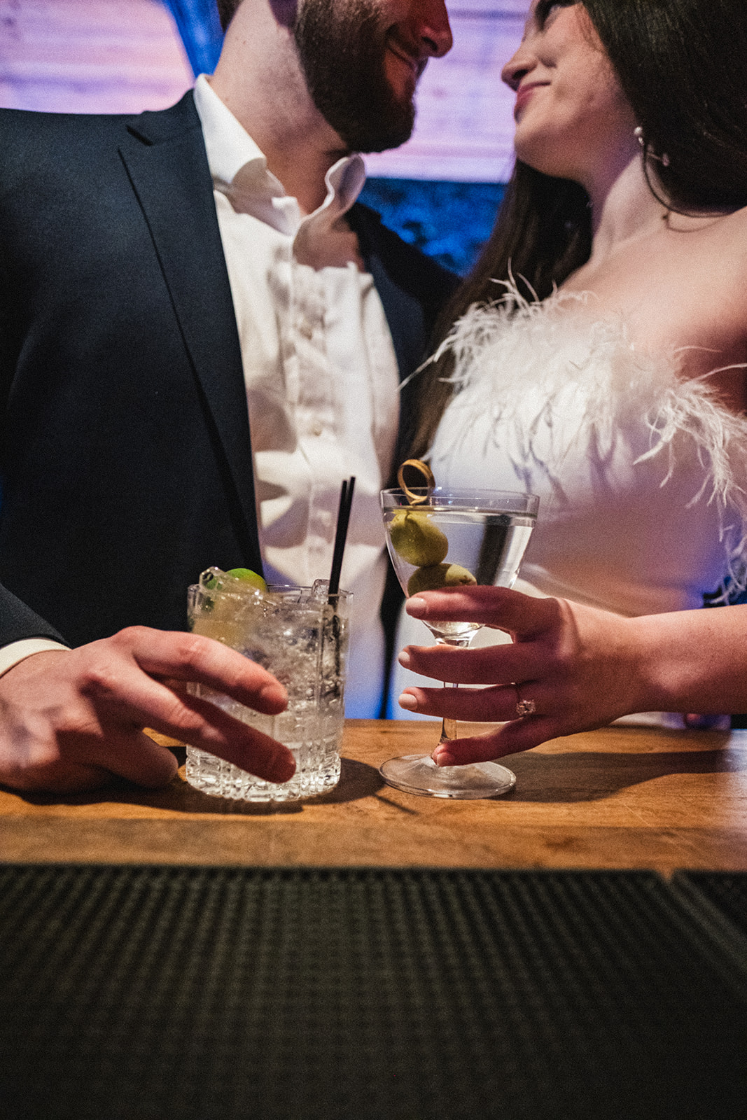 couple at the bar holding their drinks celebrating their engagement