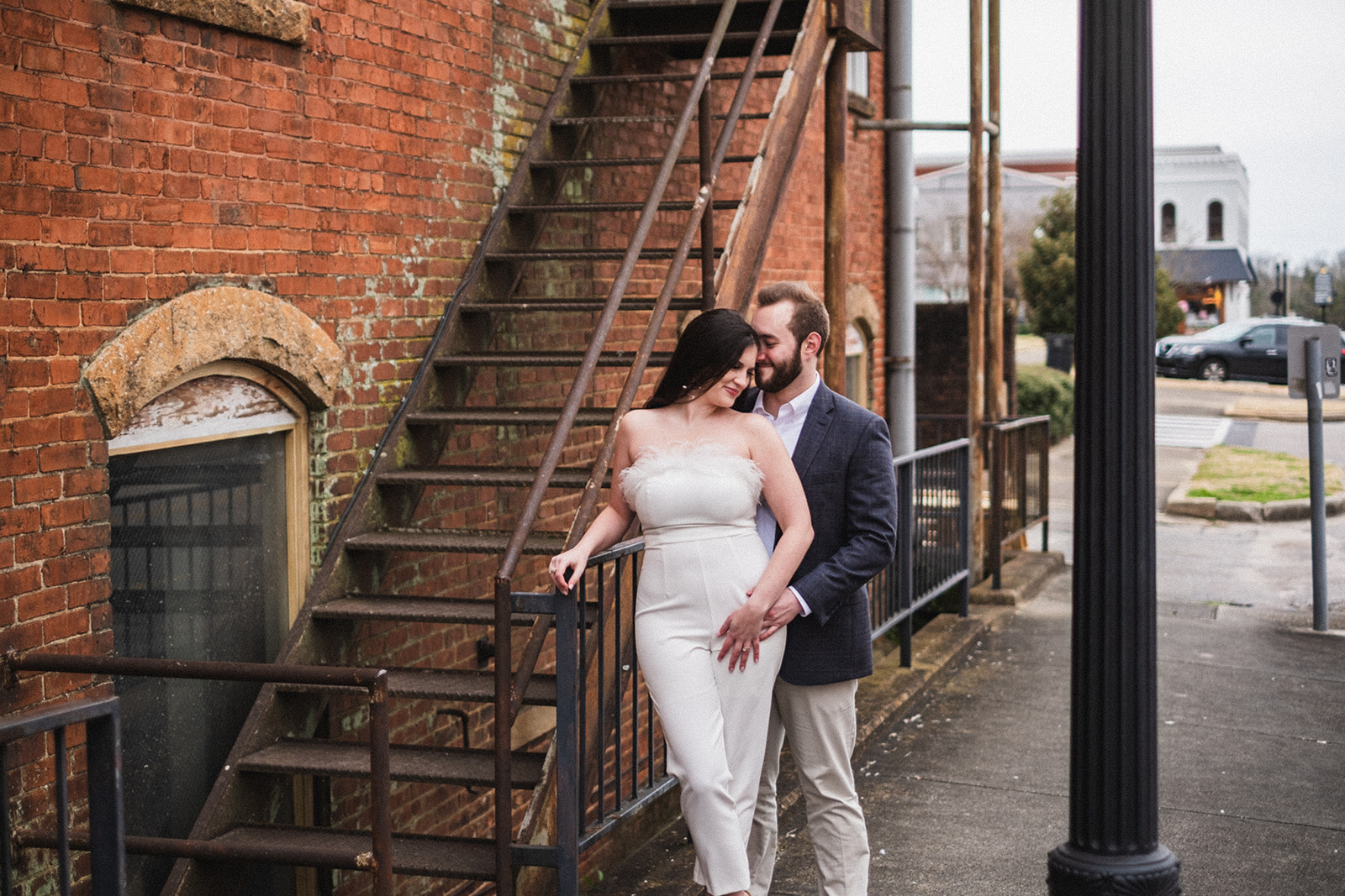 historic downtown opelika alabama engagement session between a couple posing in front of an old building