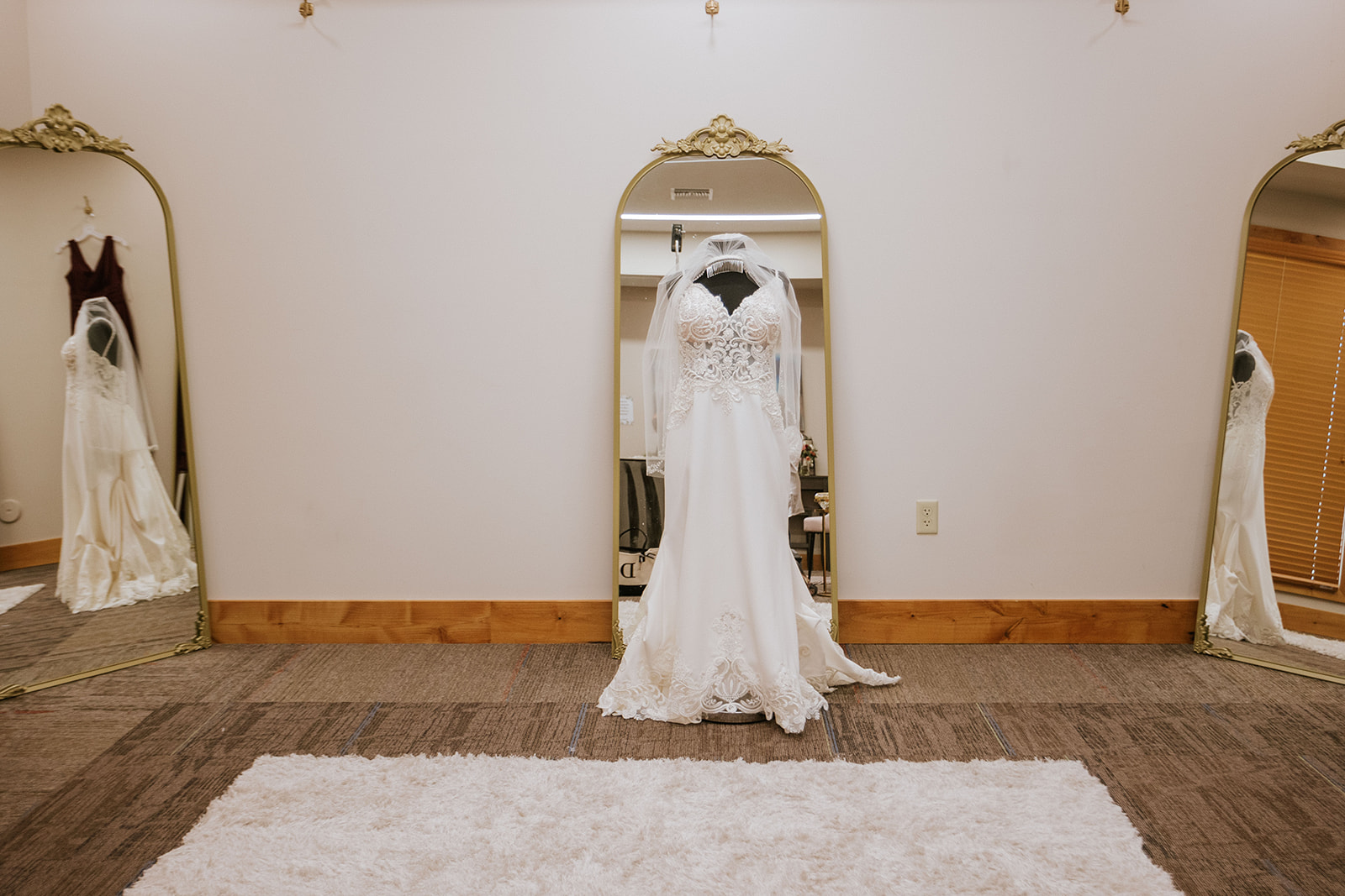 The bride's dress hanging on a mirror in her getting-ready room