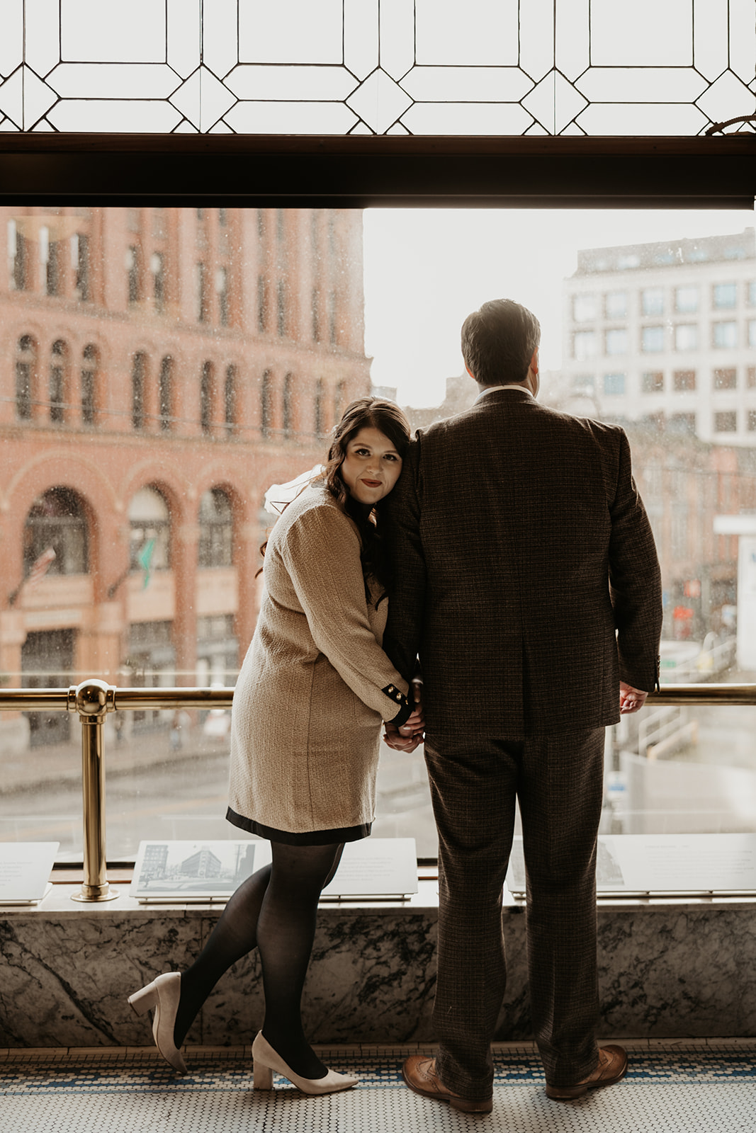 man and woman pose at smith tower in seattle