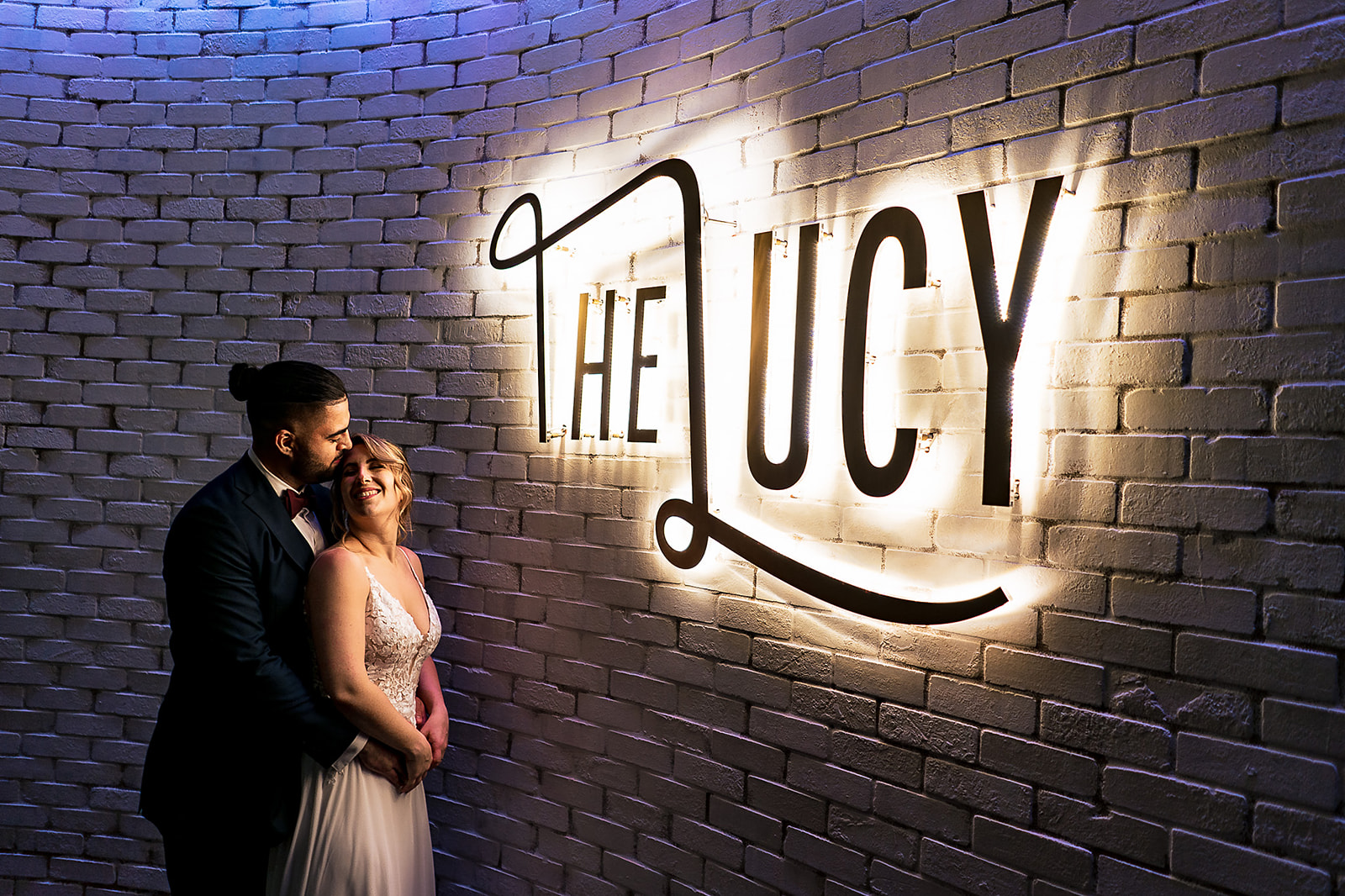 wedding portrait of couple under the lucy sign at cescaphe
