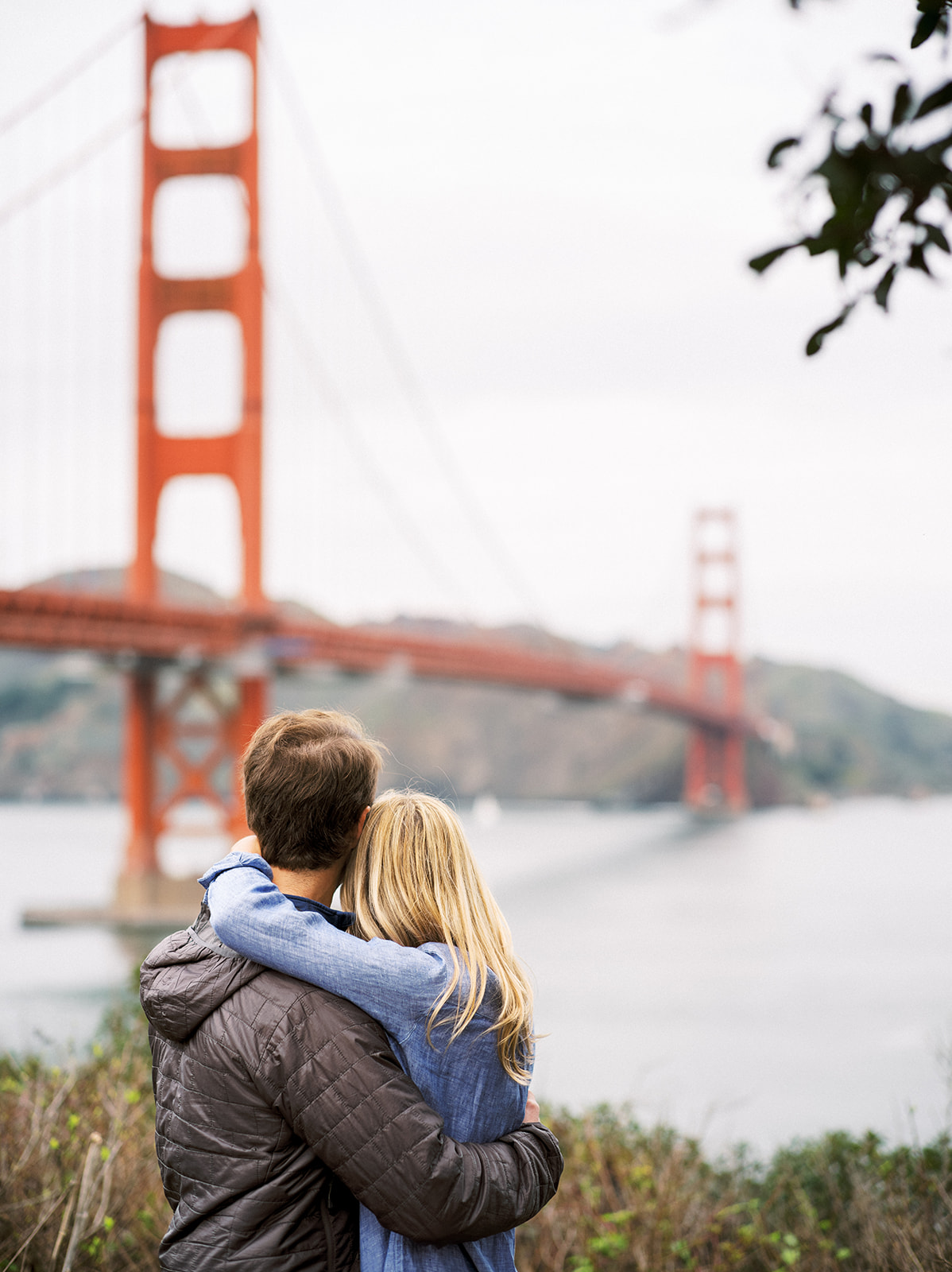 Couple pause for a moment with the Golden Gate Bridge in the background.