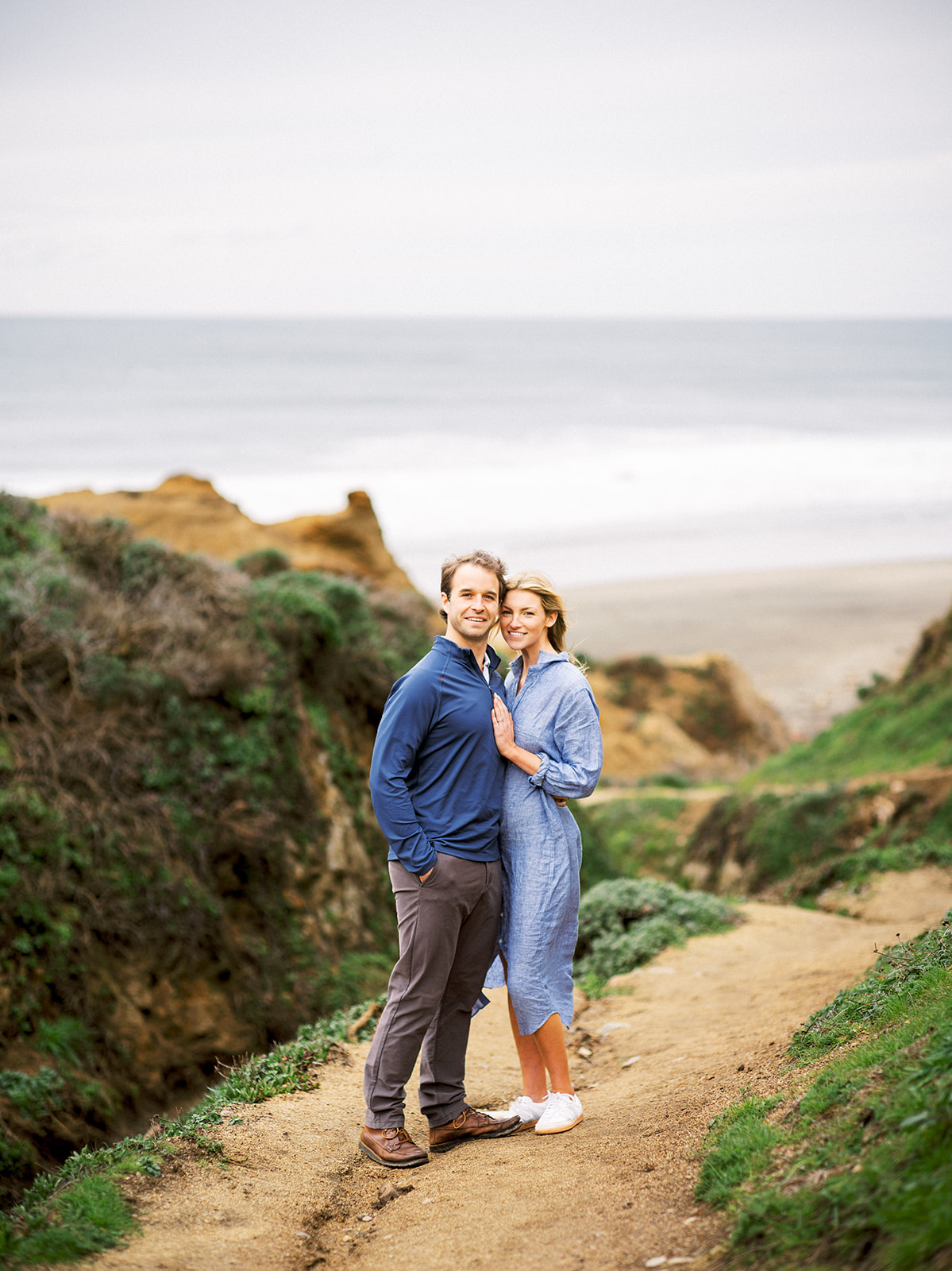 Couple standing on rocks at Mclure's beach.
