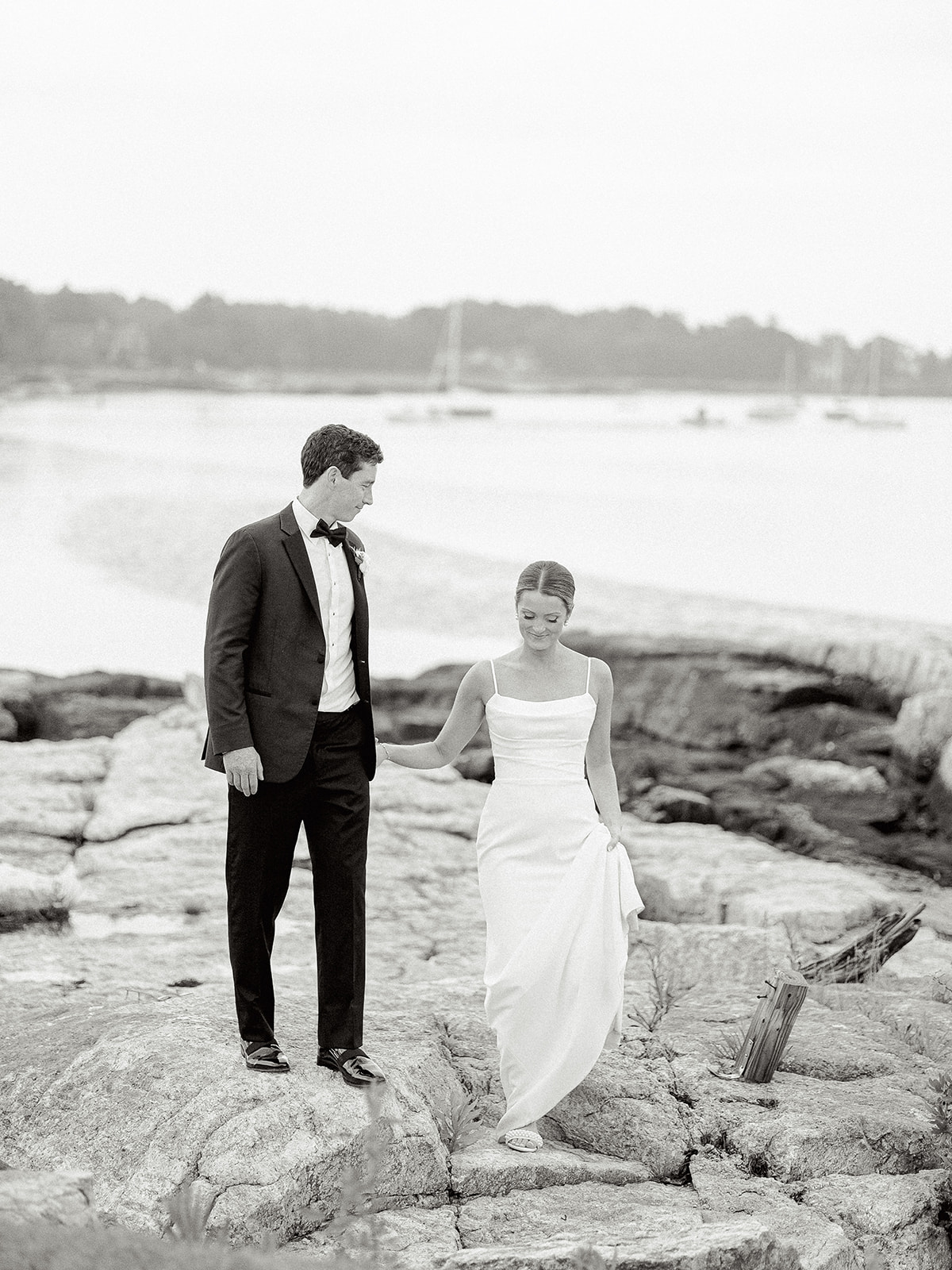 Bride and groom walking by the ocean at their Wentworth By The Sea Country Club wedding.
