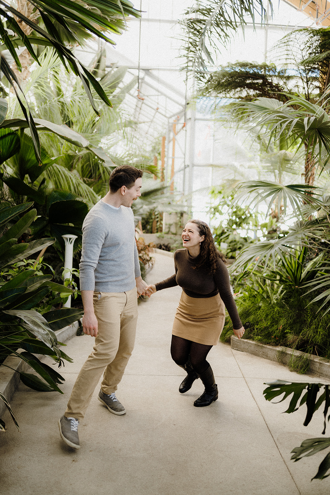 A man and woman walking beside each other in greenhouse.