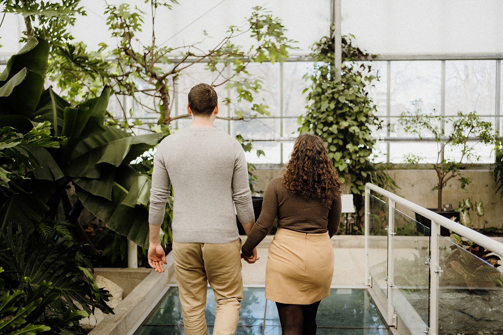 A man and woman walking down a pathway inside.