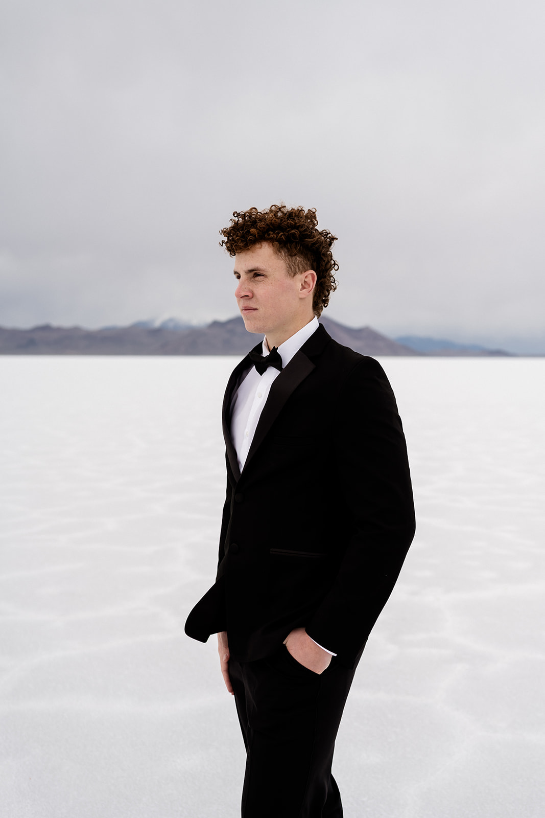 close up of groom in a tux standing on the Salt Flats