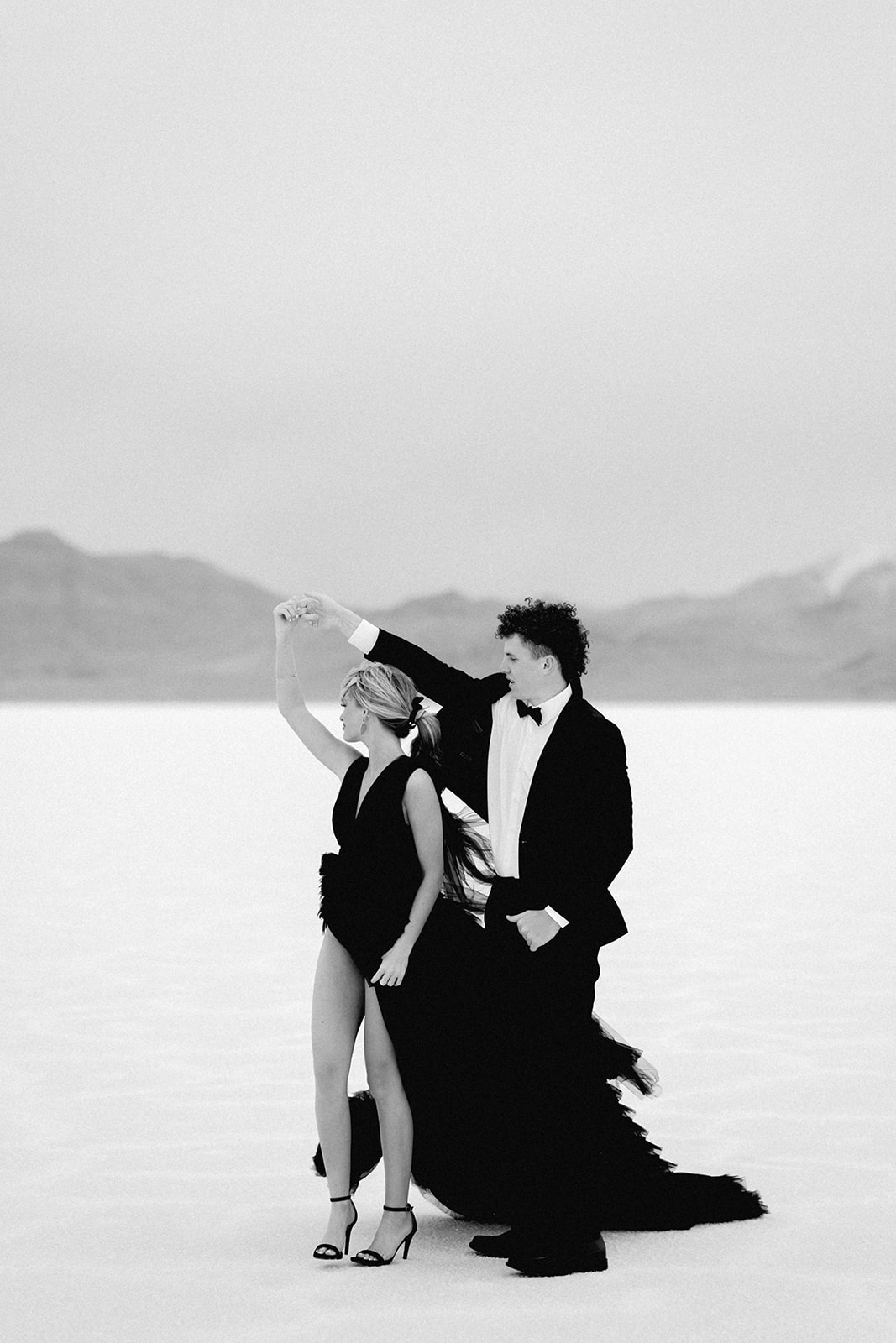 couple dancing and twirling at the salt flats in wedding attire
