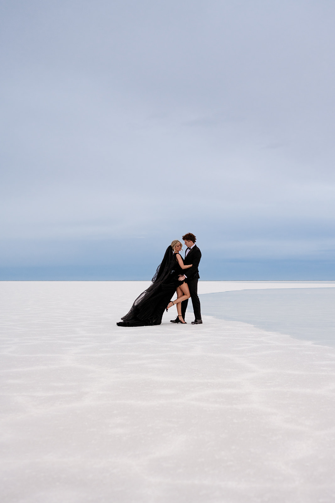 Ethereal light bathes couple in Utah Salt Flats engagement photography.