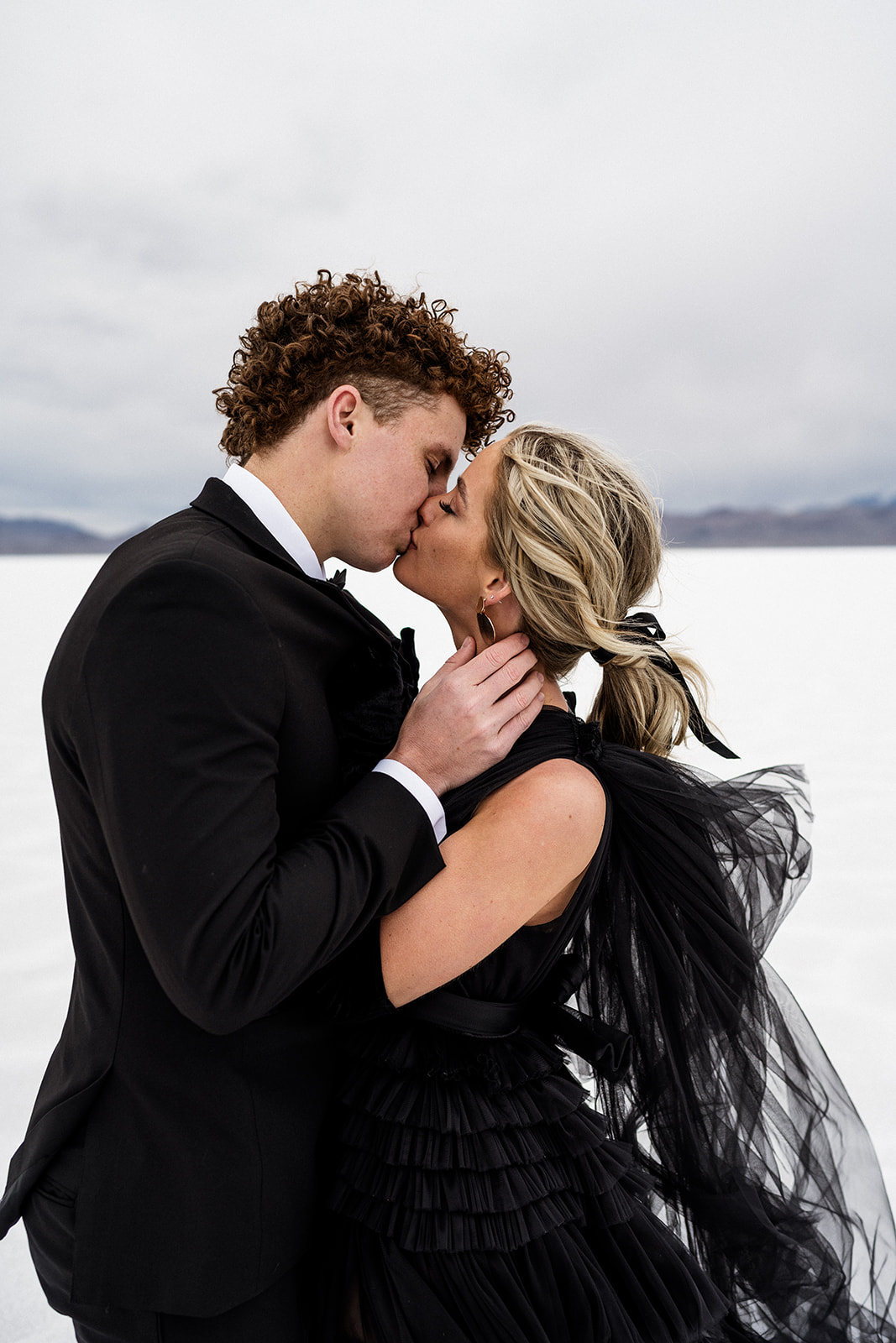 Passionate embrace at the Bonneville Salt Flats in Utah by wedding photographer