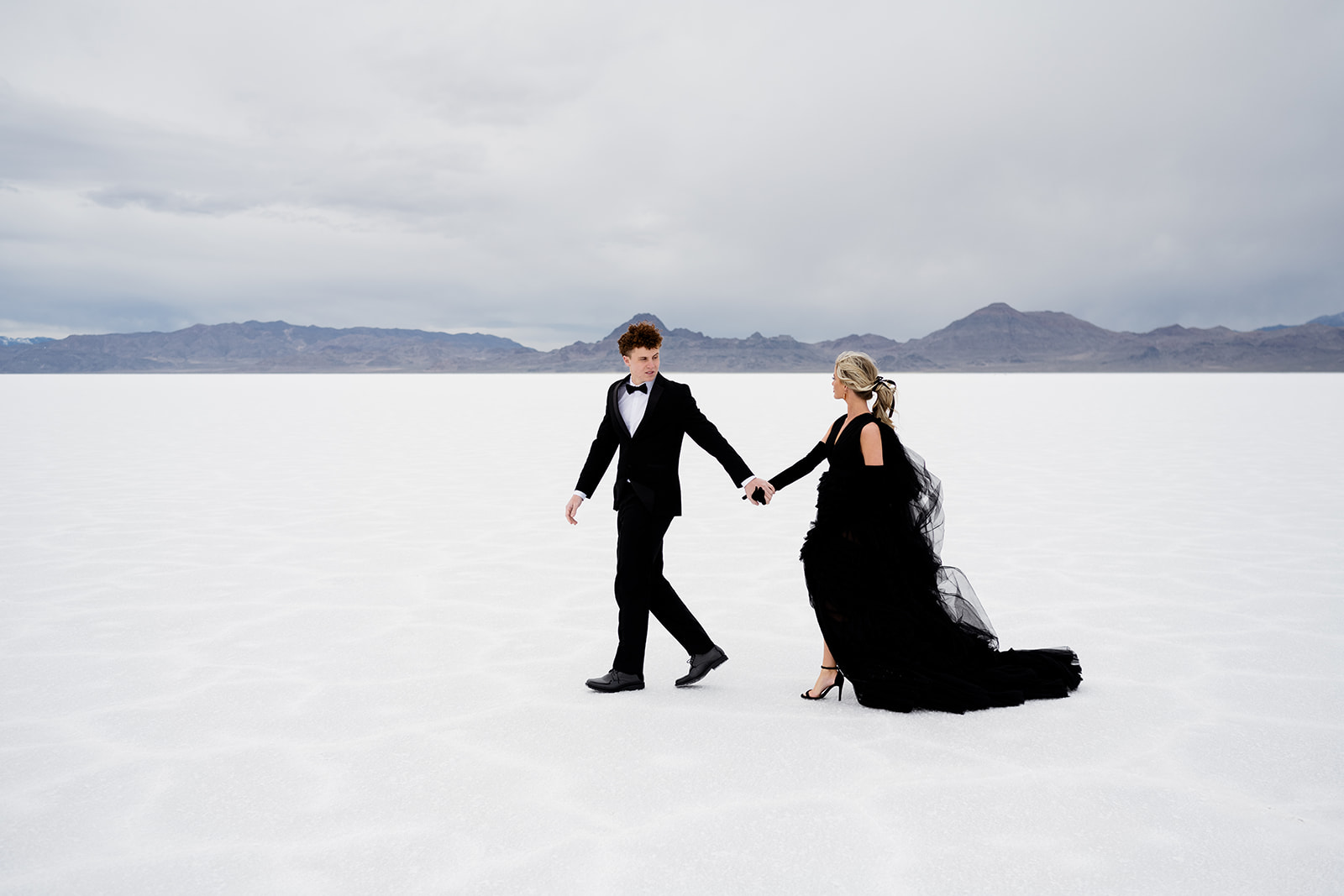 Utah photographer captures couple walking hand in hand at Salt Flats.