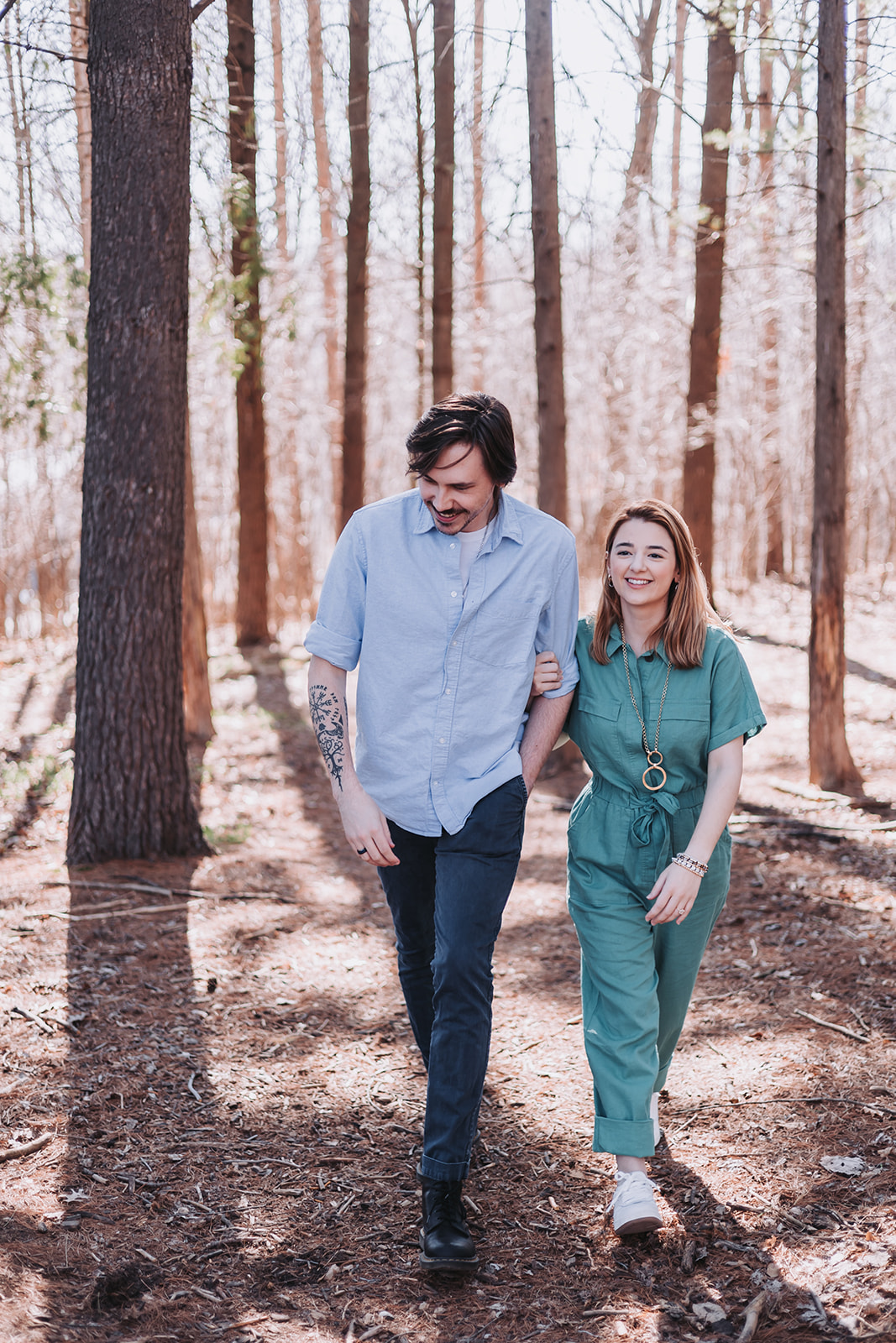 couple walking through the woods at engagement session