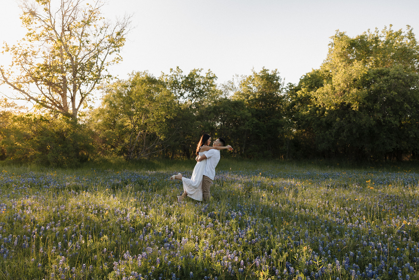 Couple hugging and running in field of Bluebonnets h at McKinney Falls state park