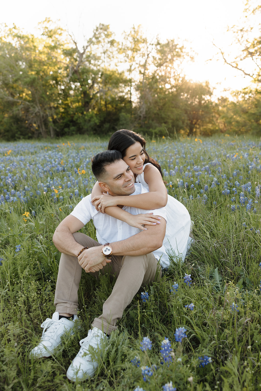 Couple sitting in field of Bluebonnets hugging at McKinney Falls state park