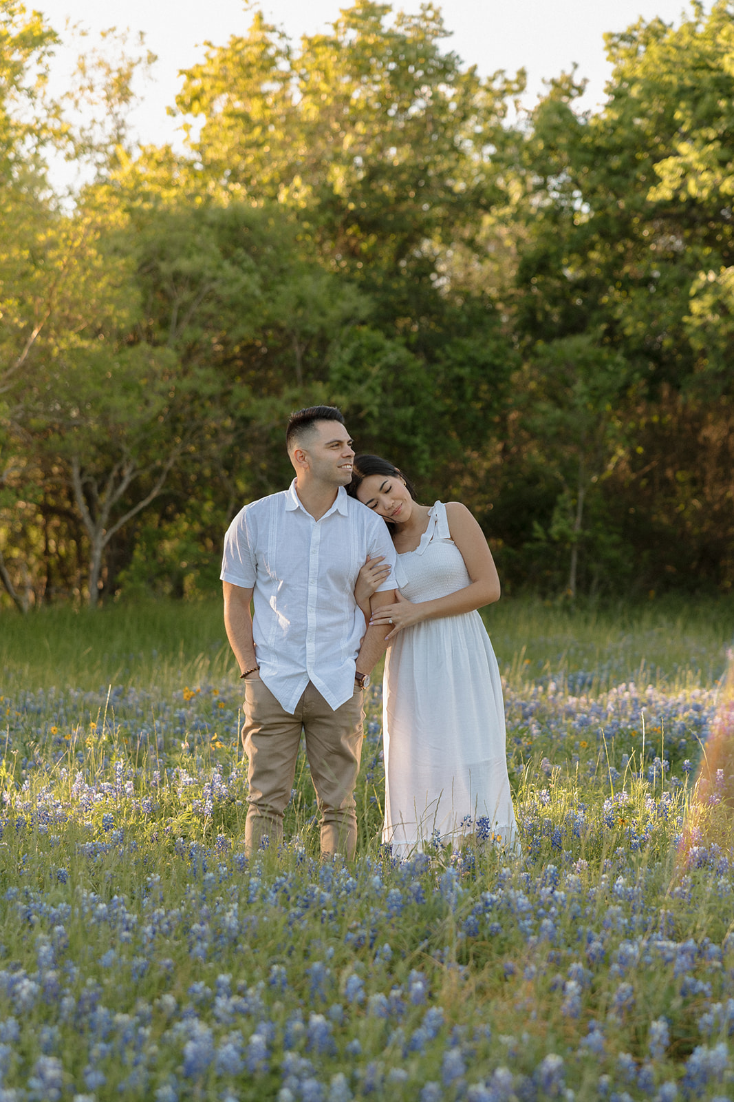 Couple wearing white hugging in a field of Bluebonnets at McKinney Falls state park