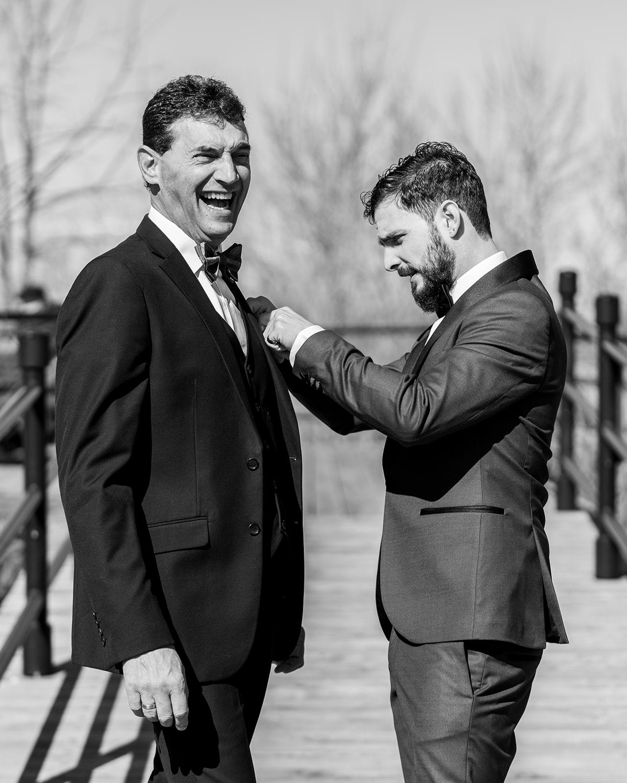 black and white groom prep, the groom adjusting his father's bow-tie