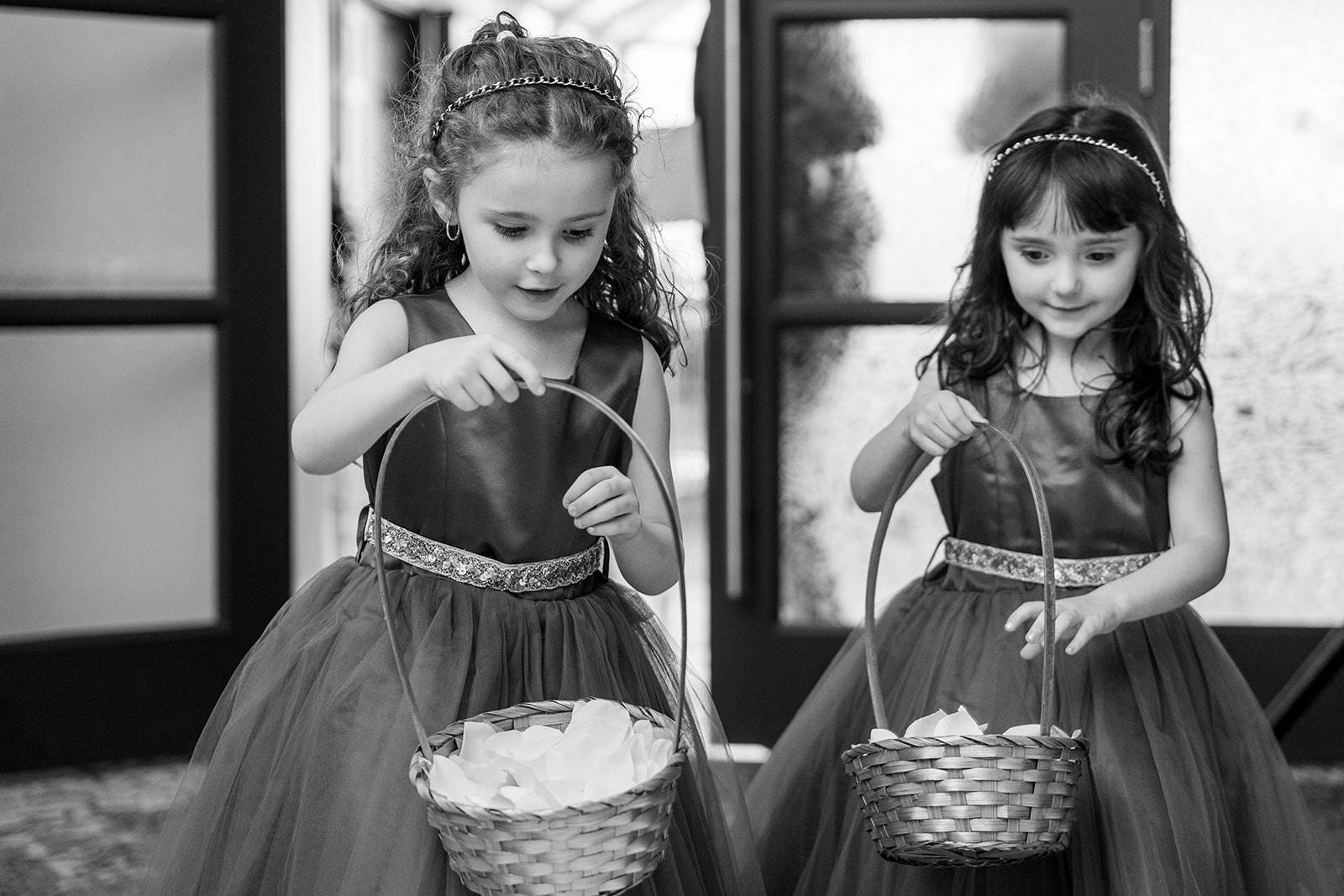 black and white photograph of two flower girls walking in 