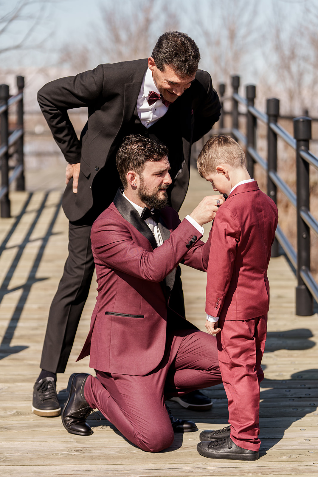 the groom getting his son ready, while the groom's father watches over them