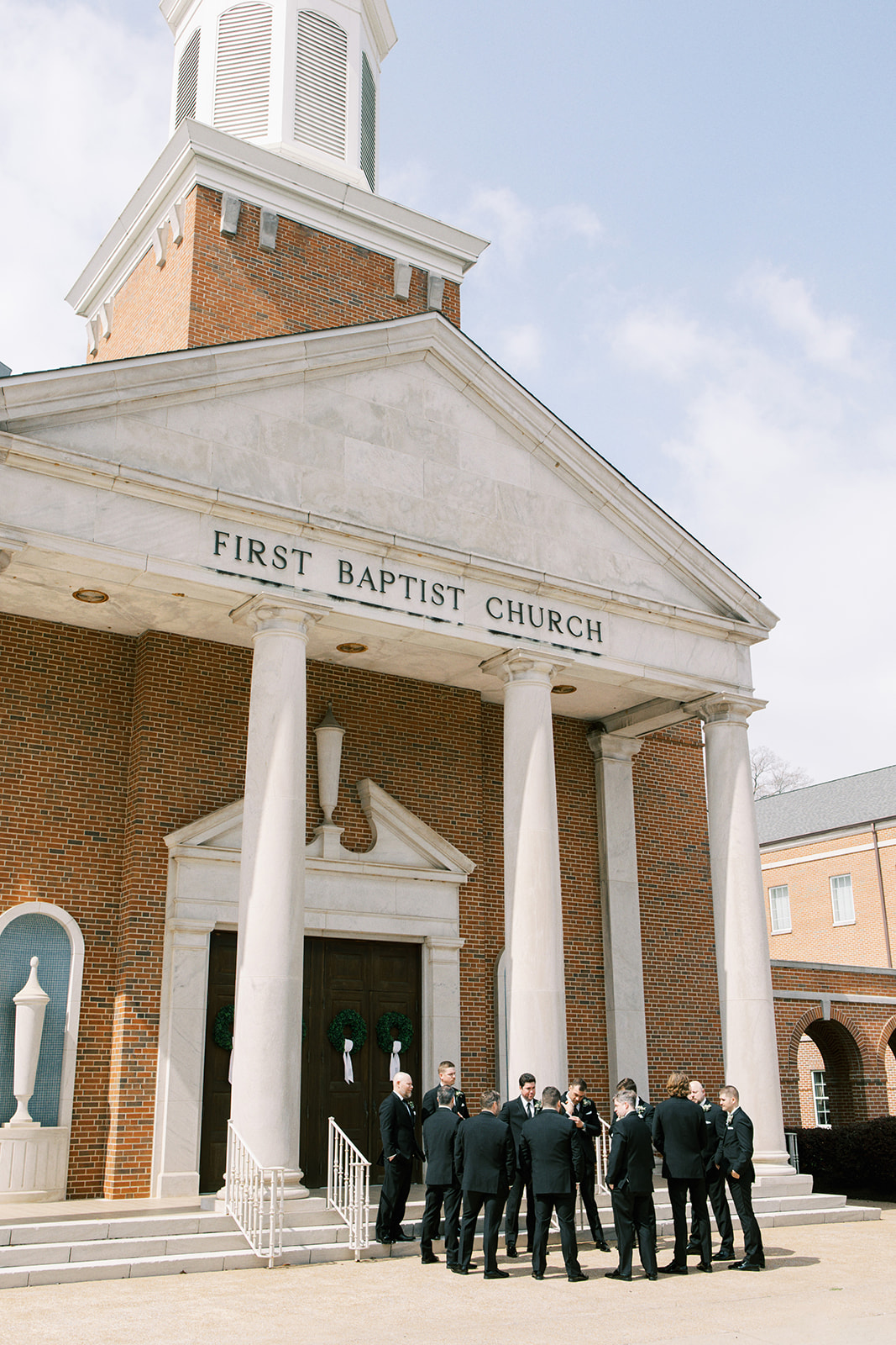 Groomsmen gather in front of Fort Payne First Baptist Church before the wedding ceremony